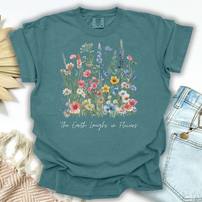 Blue Spruce garment-dyed cotton t-shirt with painterly wildflowers and "The Earth Laughs in Flowers" text.