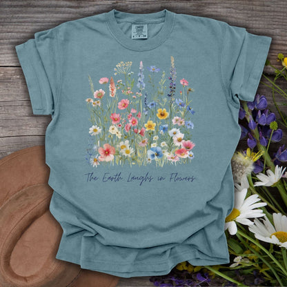 Ice Blue garment-dyed cotton t-shirt with painterly wildflowers and "The Earth Laughs in Flowers" text.