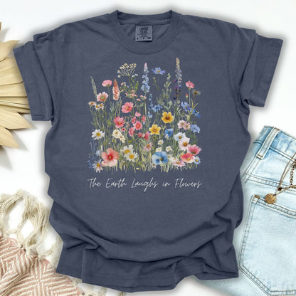 Denim garment-dyed t-shirt with painterly wildflowers and "The Earth Laughs in Flowers" text.