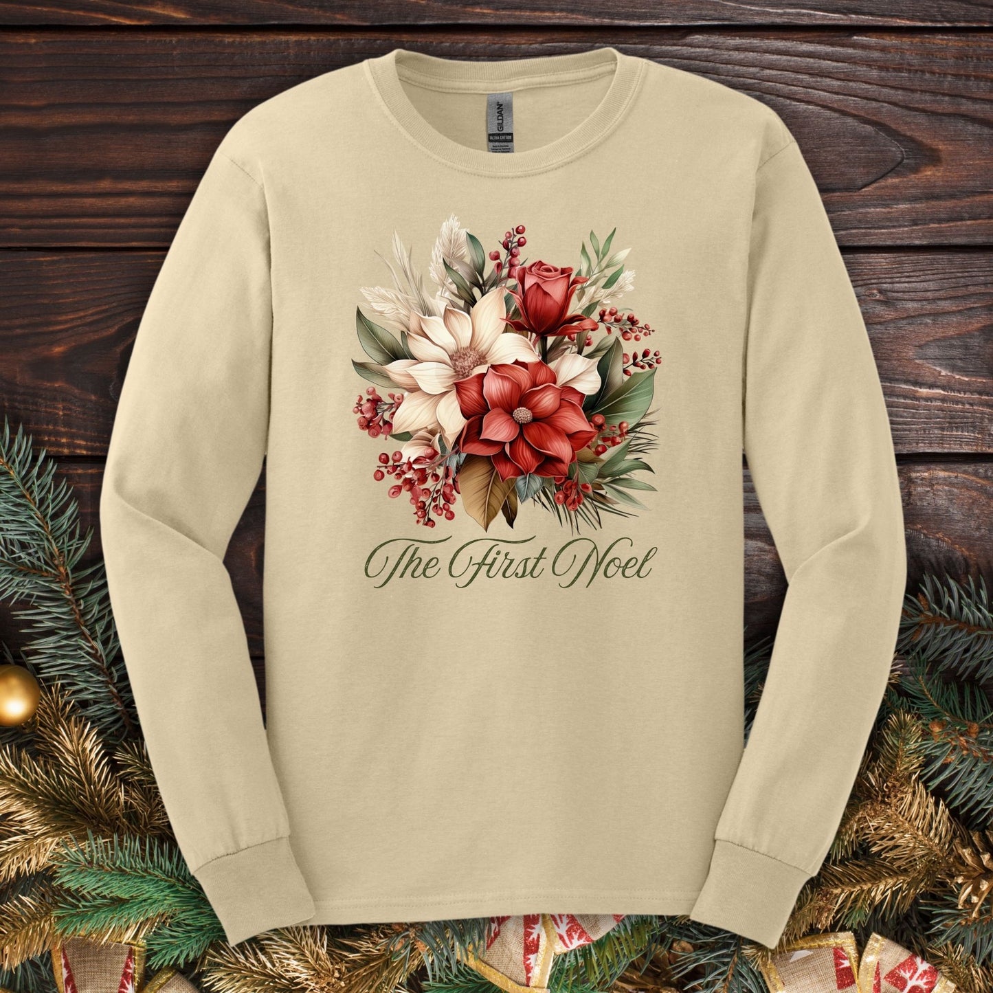 Sand Gildan long sleeve tee with a watercolor Christmas bouquet and "The First Noel" text.