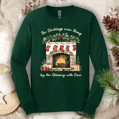 Forest Green long sleeve tee with a watercolor fireplace, red stockings, holly, and "The Stockings were Hung" text.