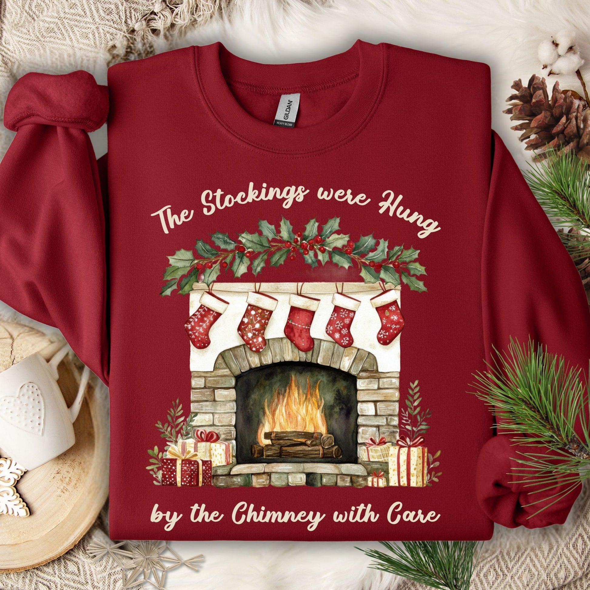 Cardinal Red Gildan crewneck sweatshirt with "The Stockings Were Hung" watercolor fireplace design.