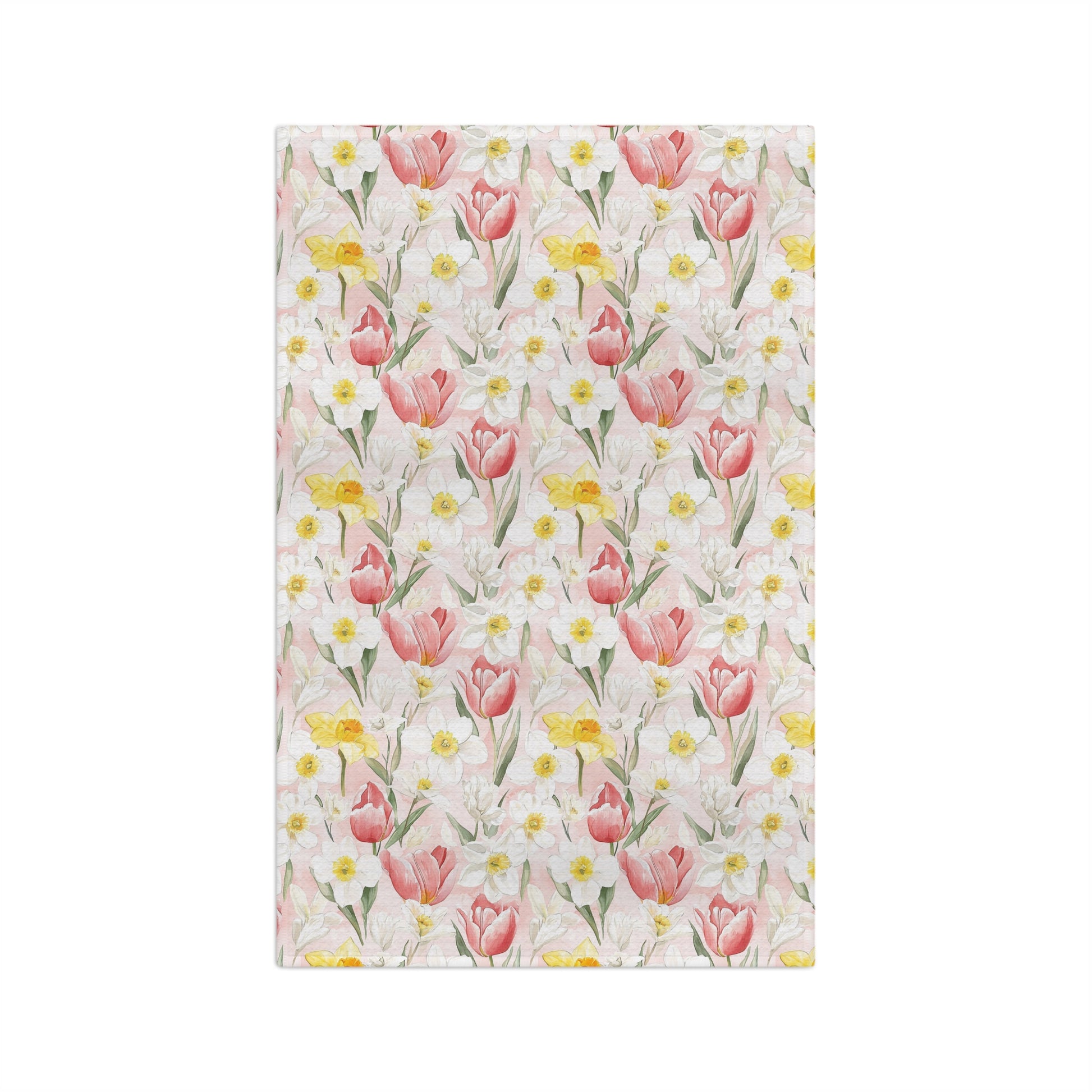 Microfiber tea towel with a watercolor pattern of pink tulips, yellow daffodils, and white daisies on a light pink background.