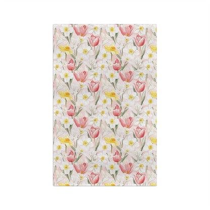 Microfiber tea towel with a watercolor pattern of pink tulips, yellow daffodils, and white daisies on a light pink background.