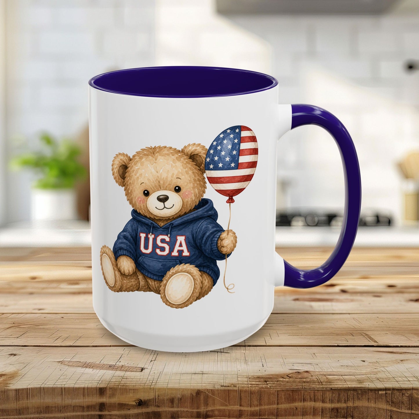 15oz ceramic mug with a cute teddy bear in a USA hoodie holding an American flag balloon, blue handle and interior.