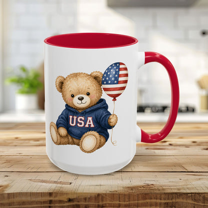 Red 15oz ceramic mug with a cute teddy bear wearing a USA hoodie and holding an American flag balloon.