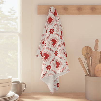 Microfiber tea towel with red hearts and pink floral pattern, hanging on a wooden peg rack.