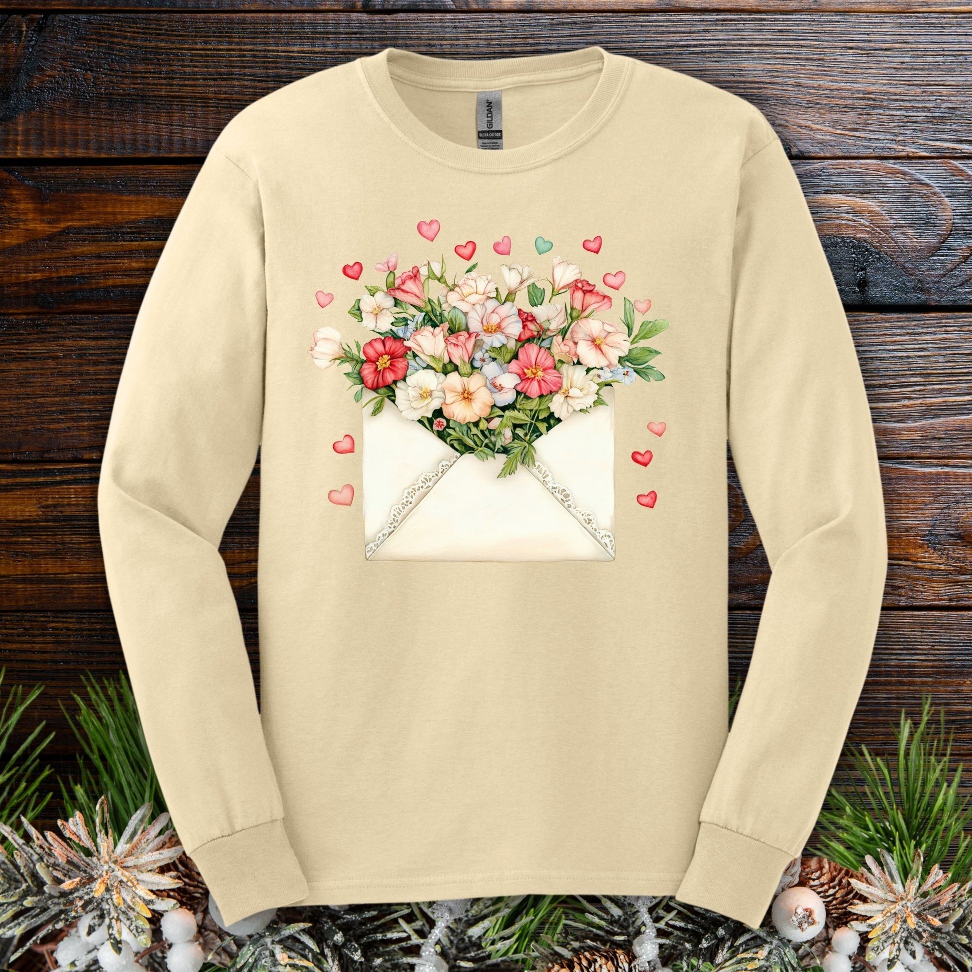 Cream long-sleeve tee with a vintage envelope design spilling pink and cream flowers and hearts.