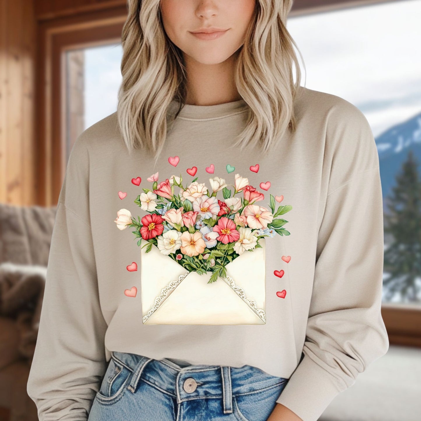 Cream long-sleeve tee with a vintage envelope design spilling pink and cream flowers and hearts.