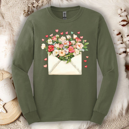Olive green long-sleeve tee with a vintage envelope design spilling pink and cream flowers and hearts.