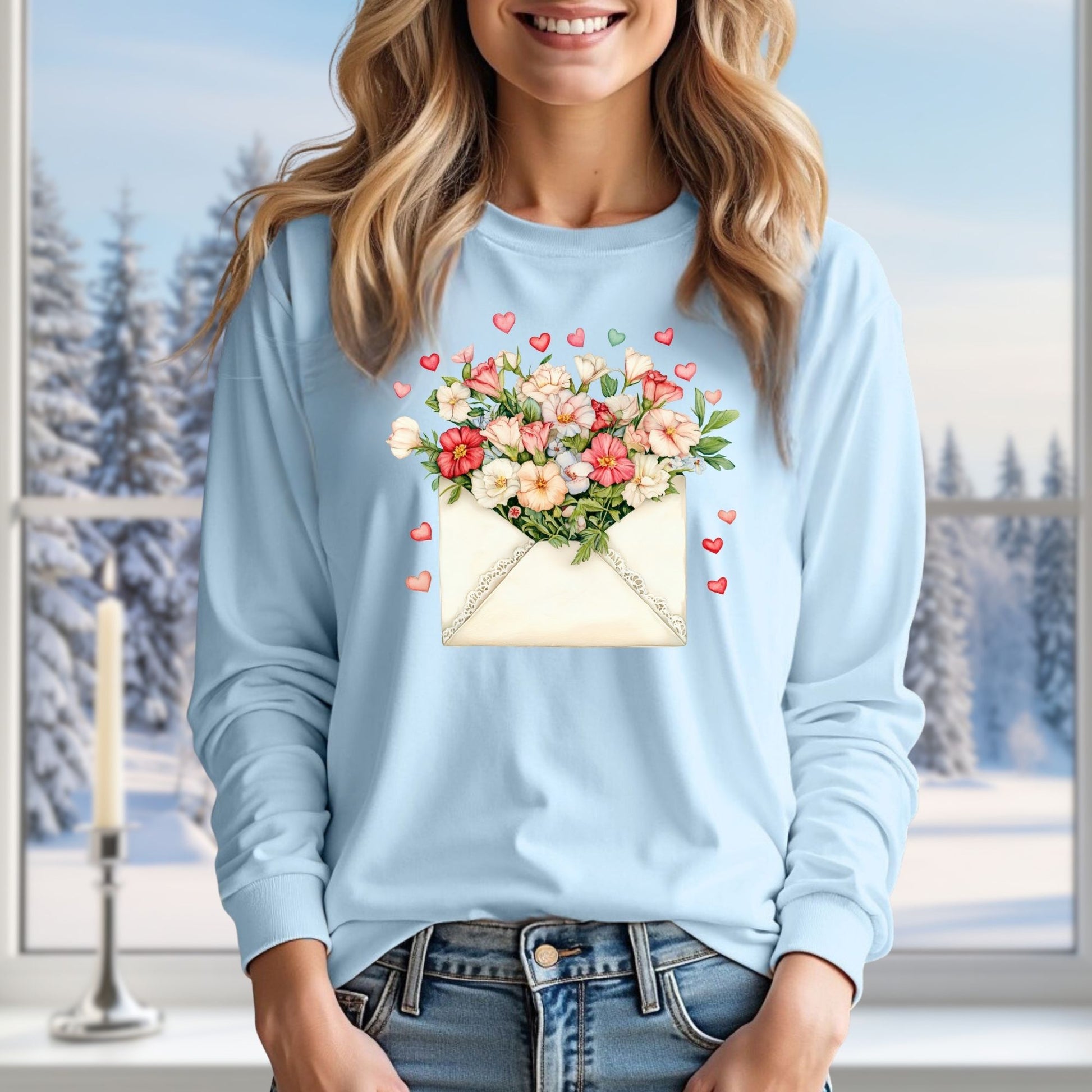 Light blue long-sleeve tee with a vintage envelope design spilling pink and cream flowers and hearts.