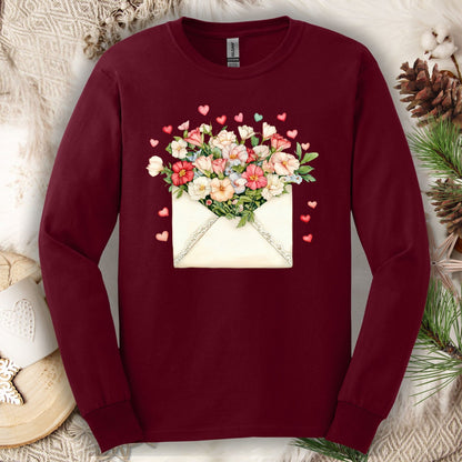 Maroon long-sleeve tee with a vintage envelope design spilling pink and cream flowers and hearts.