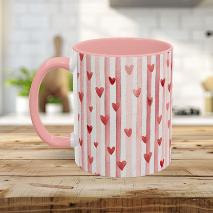 White ceramic mug with pink interior and handle, featuring watercolor pink stripes and red hearts.