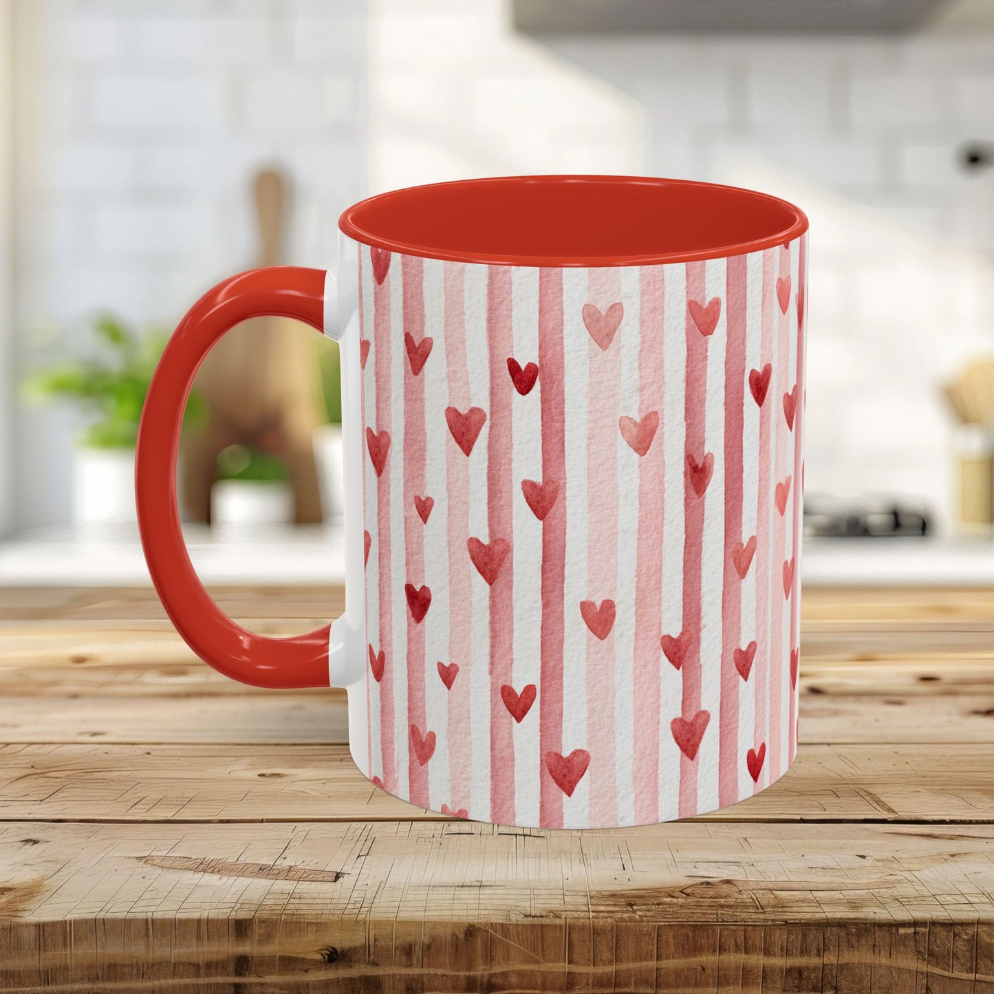 Glossy white ceramic mug with watercolor pink stripes and red hearts, red interior and C-shaped handle.