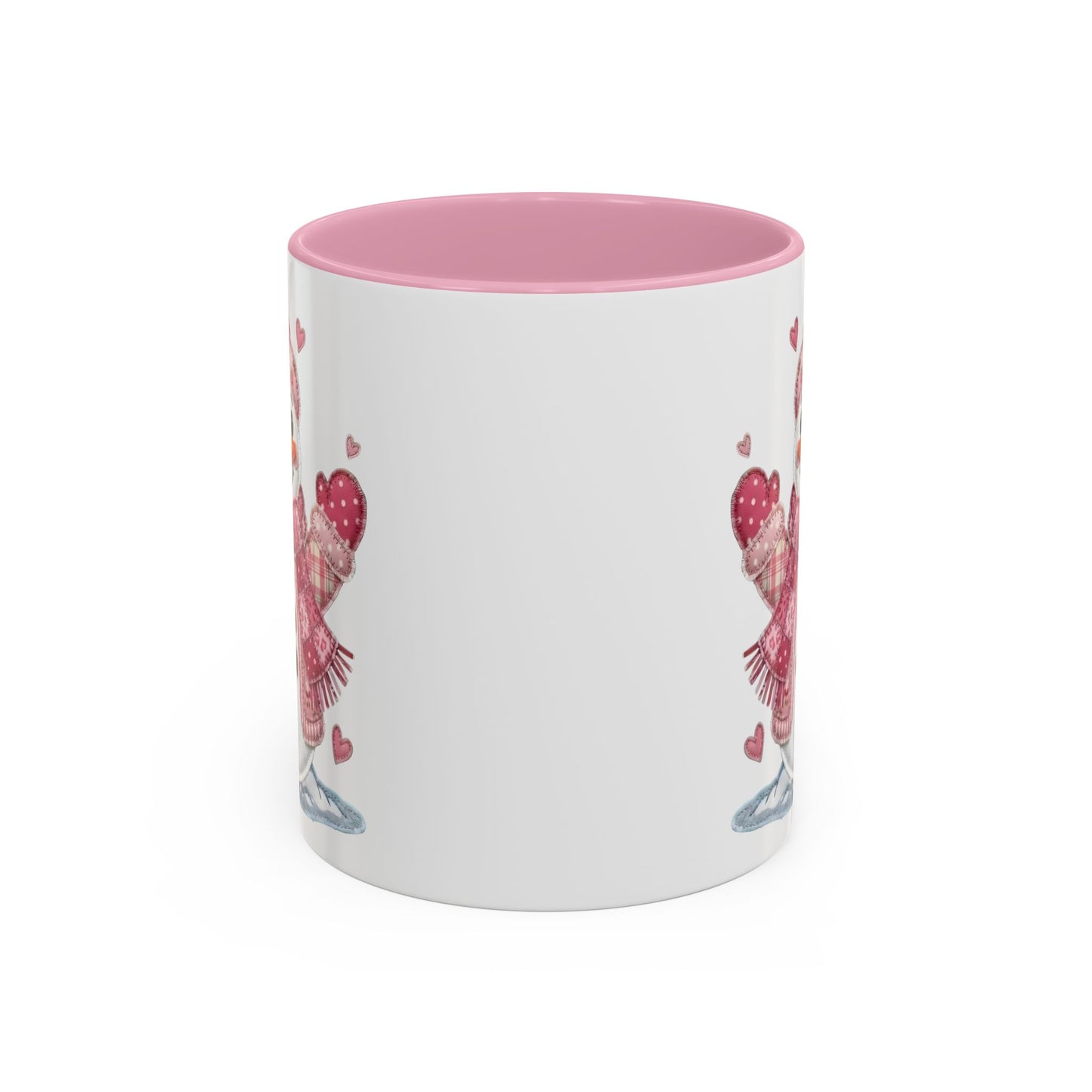 White ceramic mug with pink interior and handle, featuring a rosy patchwork snow lady design.