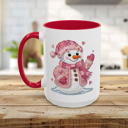 White ceramic mug with red handle and interior, featuring a rosy patchwork snow lady in pink winter attire.