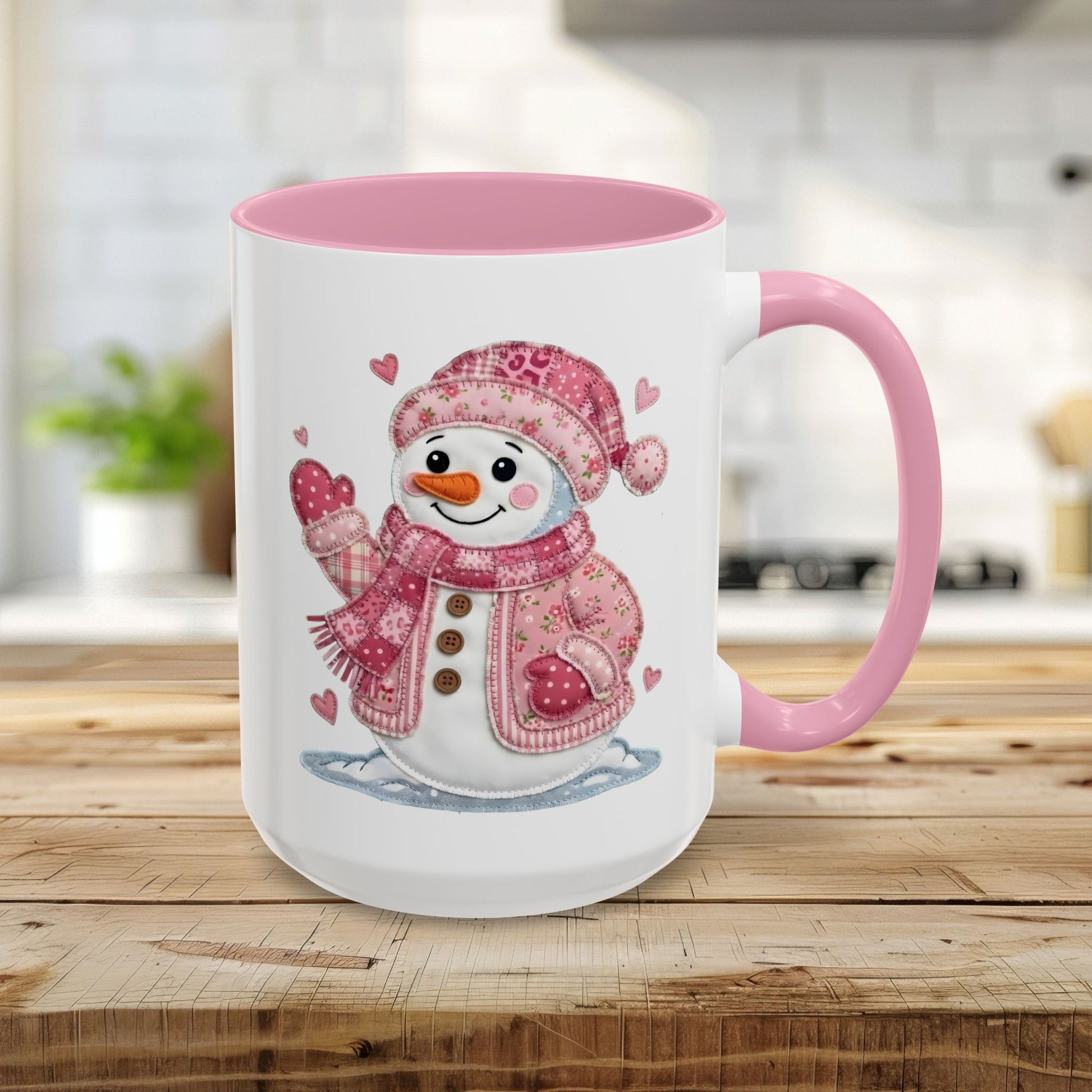 White ceramic mug with pink handle and interior, featuring a rosy patchwork snow lady design.