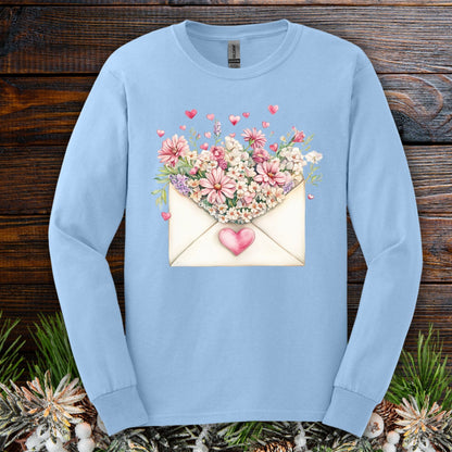 Light blue long sleeve tee with a vintage heart envelope overflowing with pink flowers and hearts.