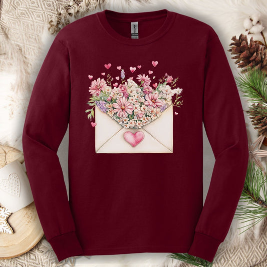 Maroon long sleeve tee with a vintage heart envelope overflowing with pink flowers and hearts.
