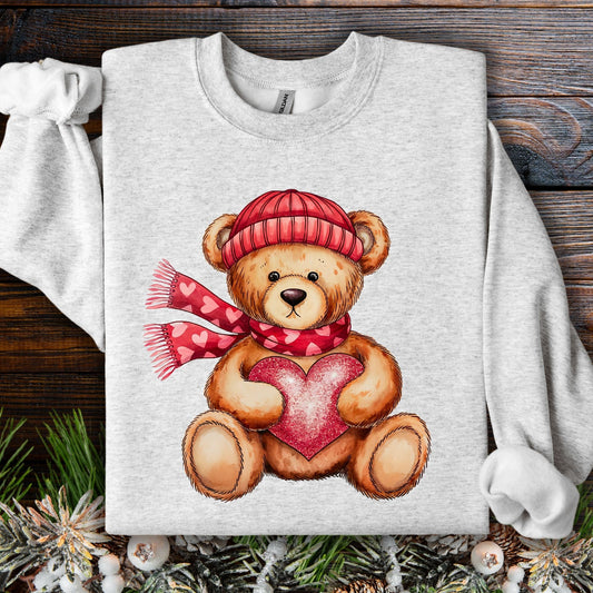 Ash S sweatshirt with a teddy bear in a red hat and scarf holding a glittery red heart.