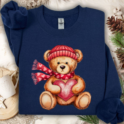 Navy S sweatshirt with a teddy bear in a red hat and scarf holding a glittery red heart.