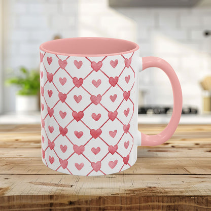 11oz ceramic mug with pink interior/handle and a watercolor geometric heart pattern in layered pinks and reds.