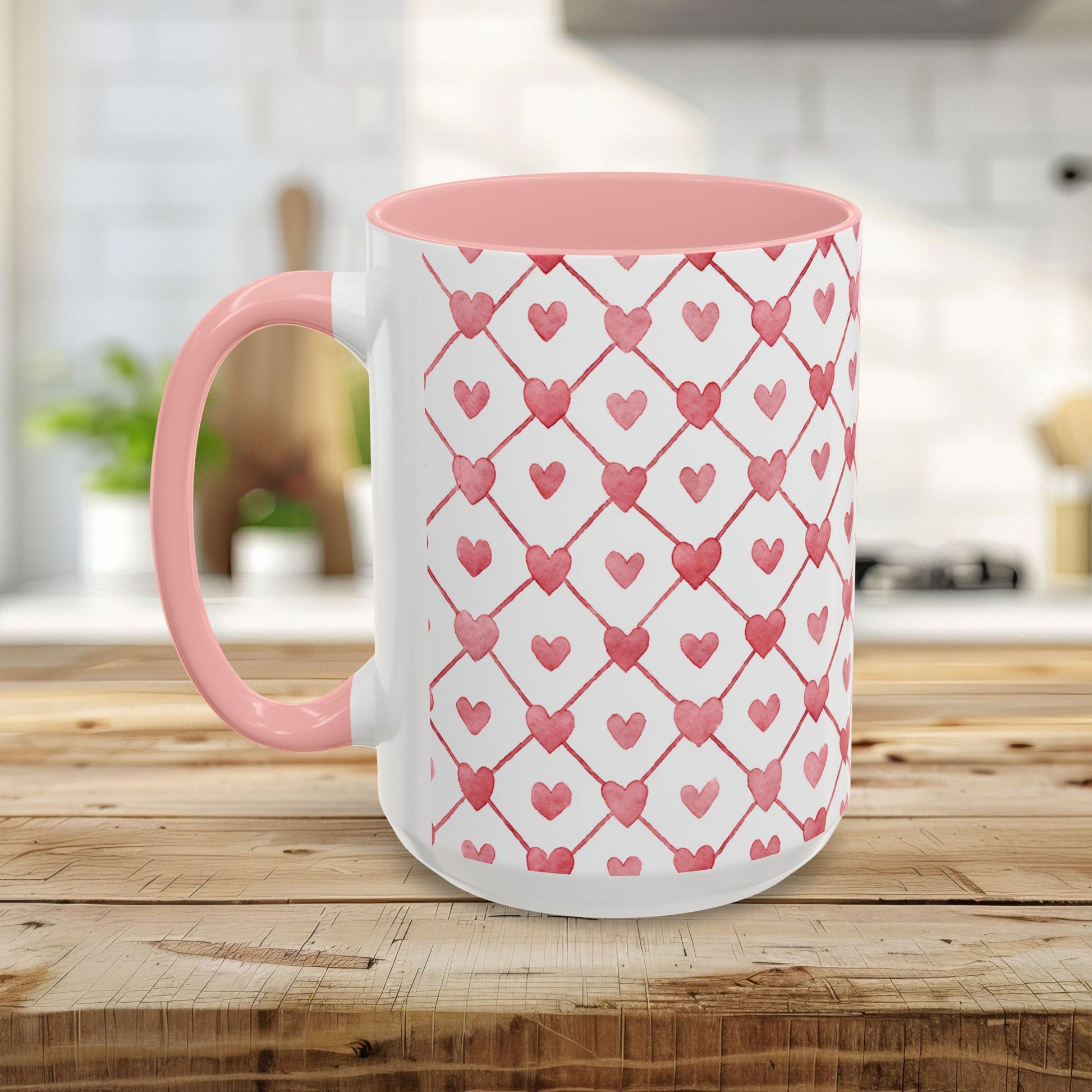 White ceramic mug with a pink interior and handle, featuring a watercolor geometric heart pattern in layered pinks and reds.