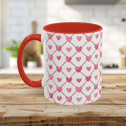 White ceramic mug with a red handle and interior, featuring a watercolor geometric heart pattern.