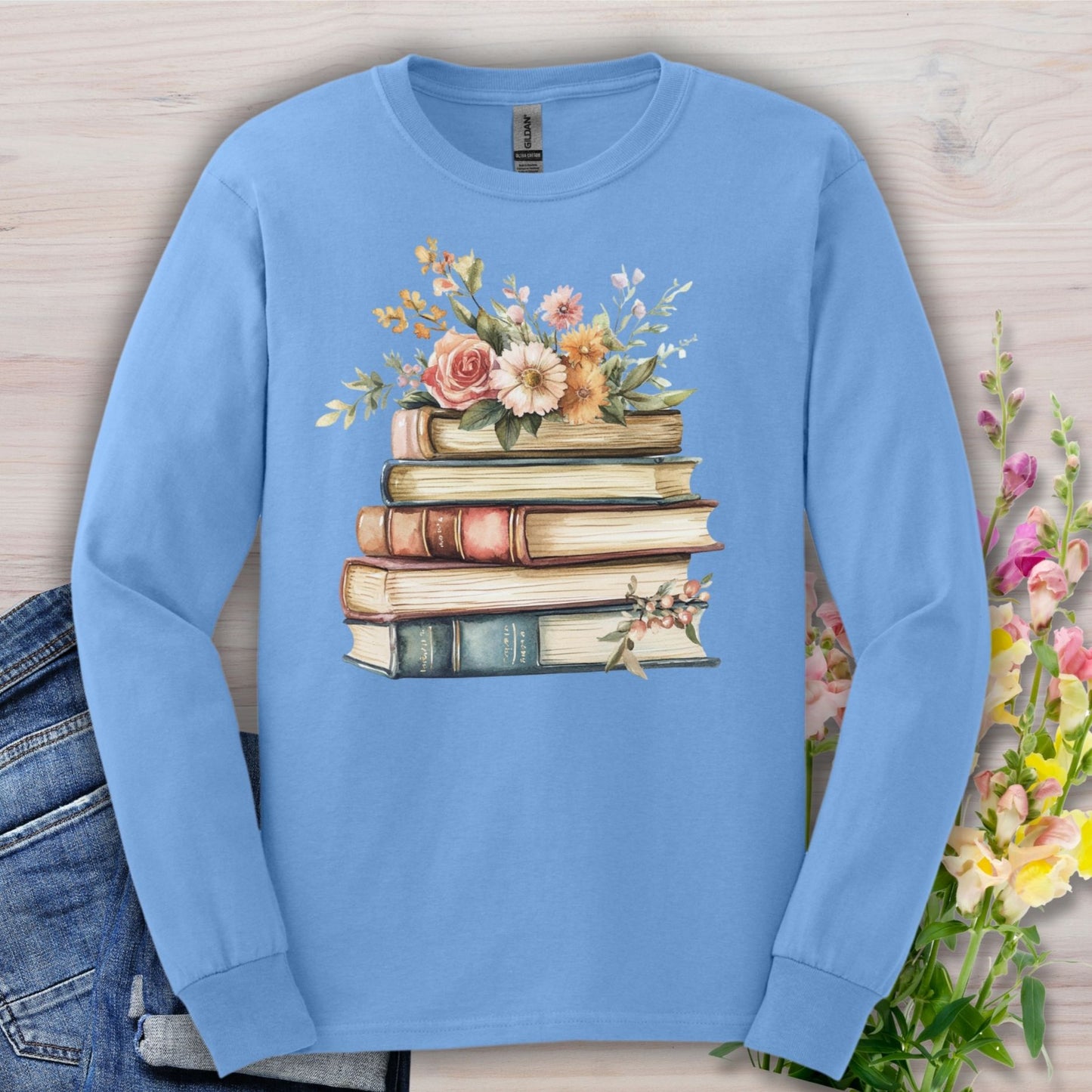 Carolina Blue long sleeve tee with a stack of vintage books blooming with delicate flowers.