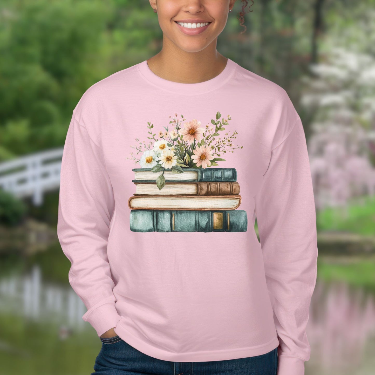 Soft pink long-sleeve tee with a vintage stack of books and wildflowers design.