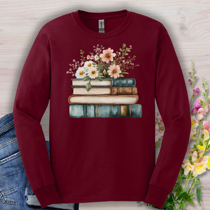 Maroon long-sleeve tee with a vintage stack of books and wildflowers design, soft cotton.