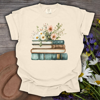 Ivory garment-dyed cotton t-shirt with a vintage illustration of stacked books and wildflowers.