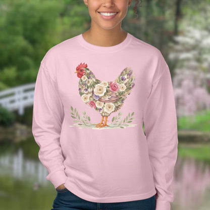 Pink long-sleeve tee with a floral hen design in muted roses and greenery, worn by a smiling person.