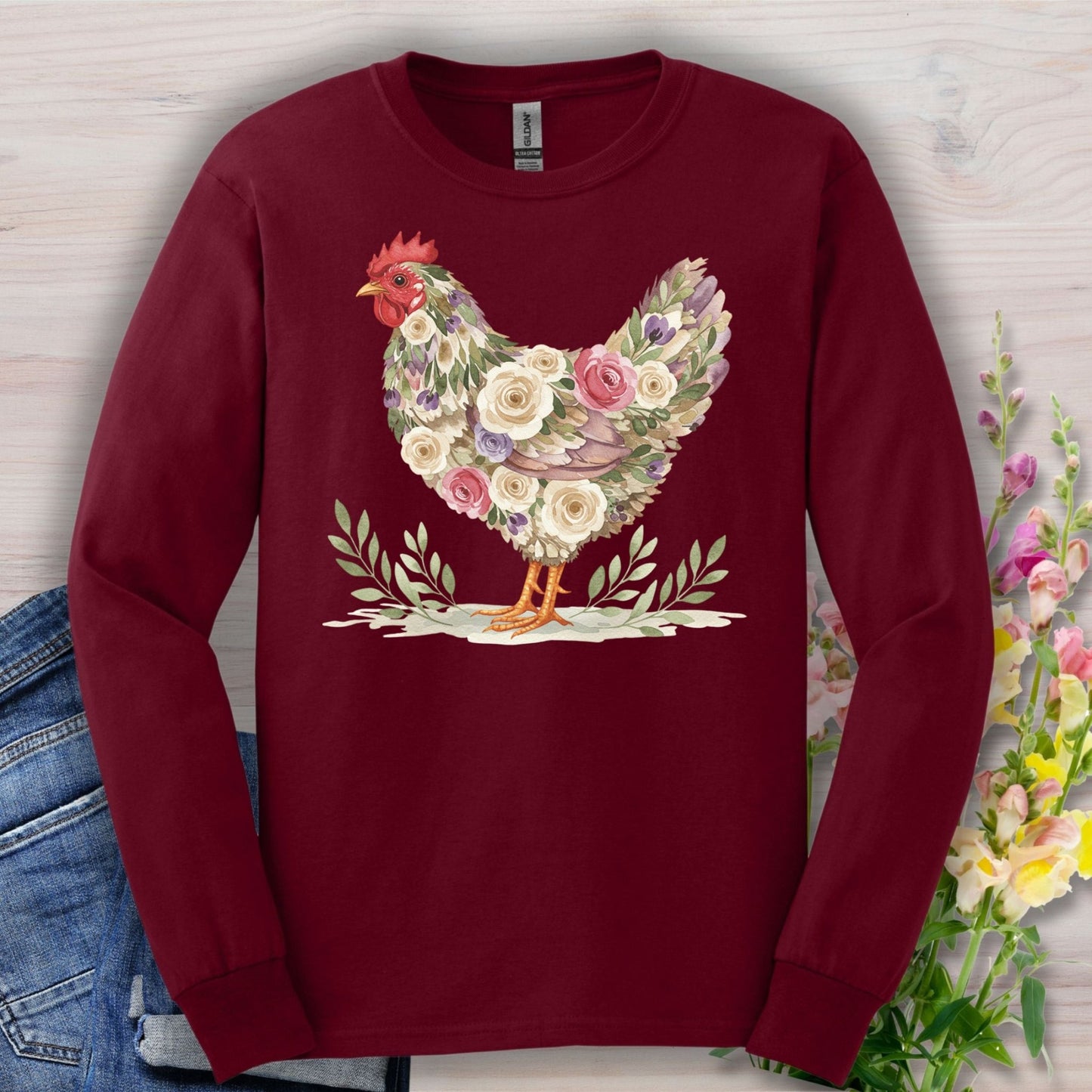 Maroon long sleeve tee with a floral-patterned hen design in muted roses, greenery, and a red comb.