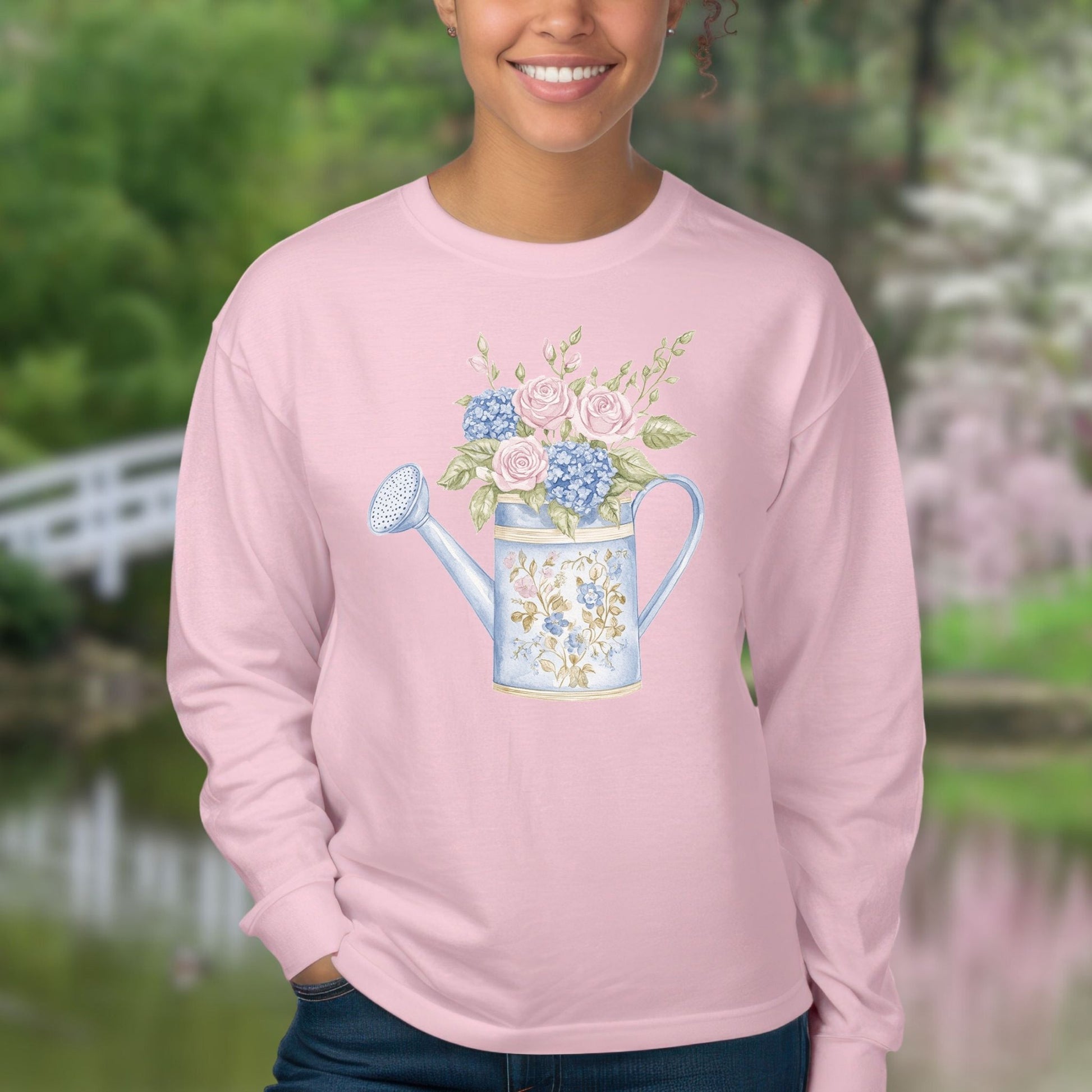 Pink long sleeve tee with a watercolor vintage watering can filled with roses and hydrangeas.