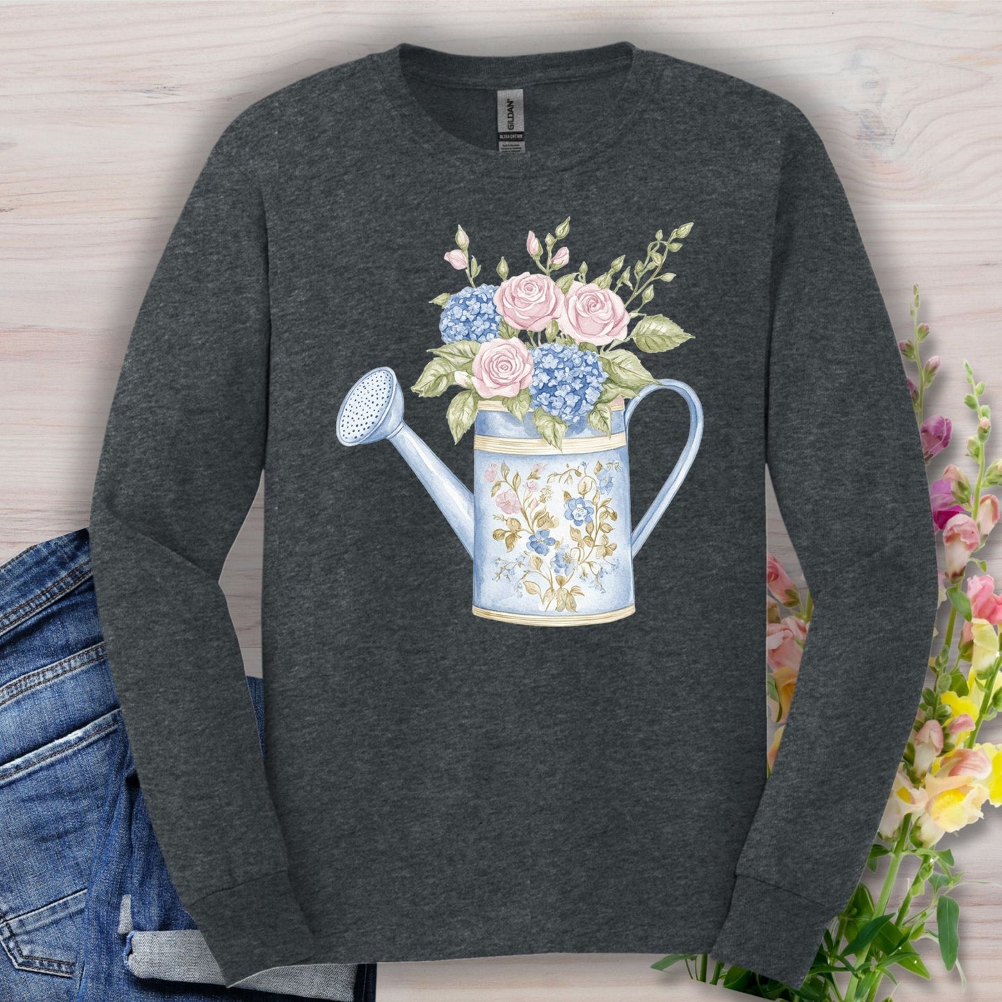 Dark Heather S long sleeve tee with a watercolor vintage watering can, pink roses, and blue hydrangeas.