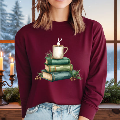 Woman in a maroon long-sleeve tee with a watercolor design of stacked vintage green books and a steaming coffee mug.