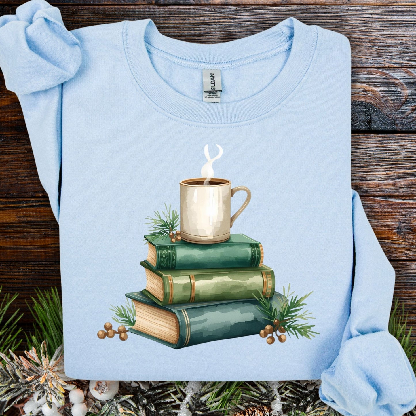 Light blue heavy blend sweatshirt with a watercolor design of green vintage books and a coffee cup.