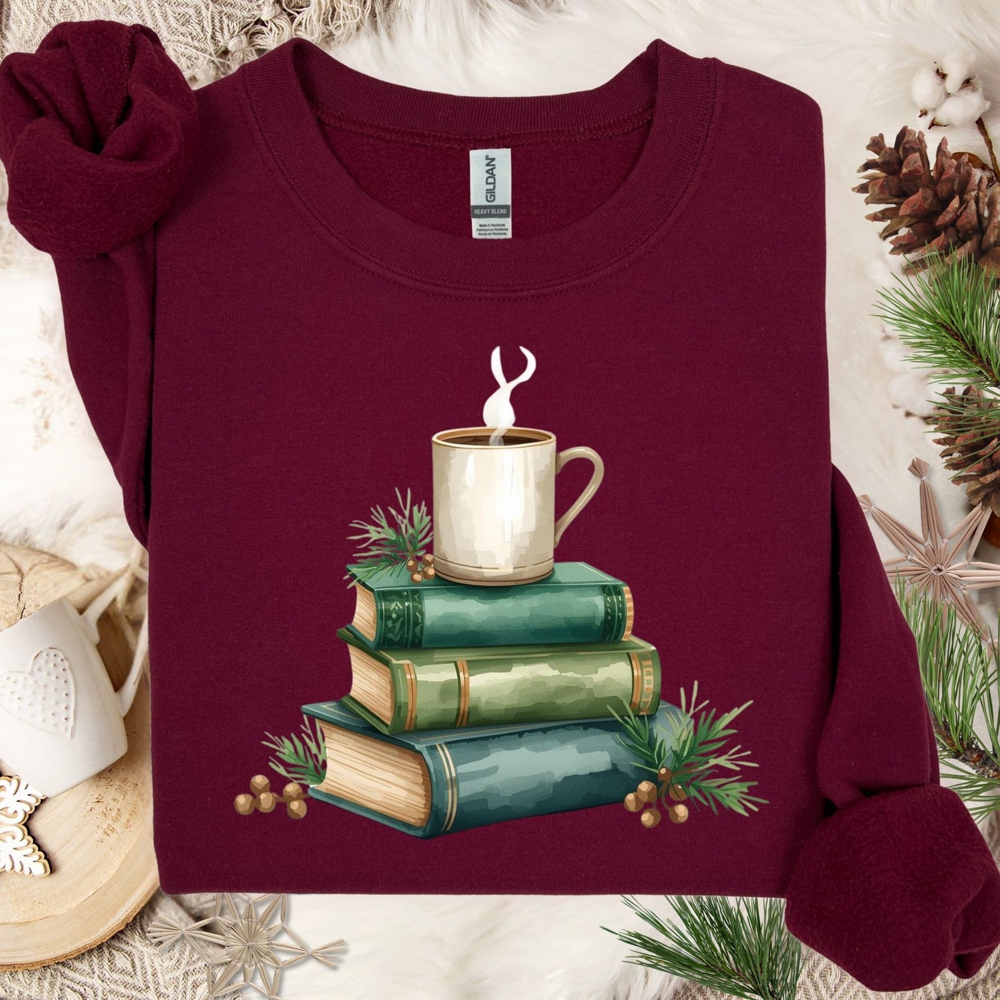 Maroon heavy blend sweatshirt with a watercolor design of green vintage books and a coffee cup.