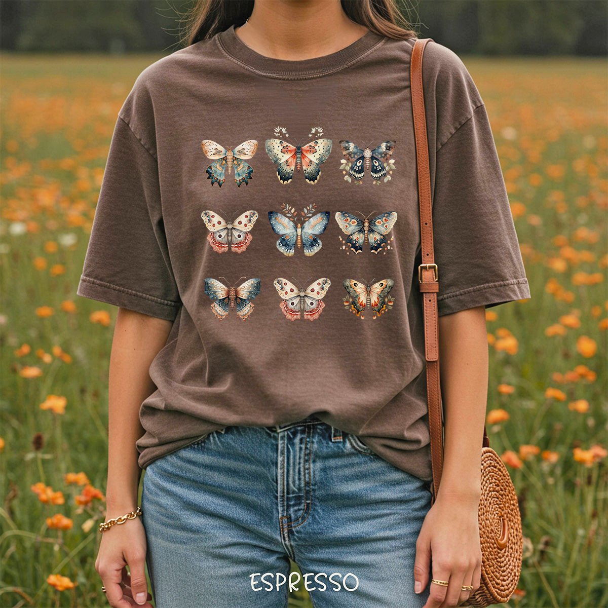 Espresso brown garment-dyed cotton t-shirt featuring a grid of vintage-style watercolor moth and butterfly illustrations.