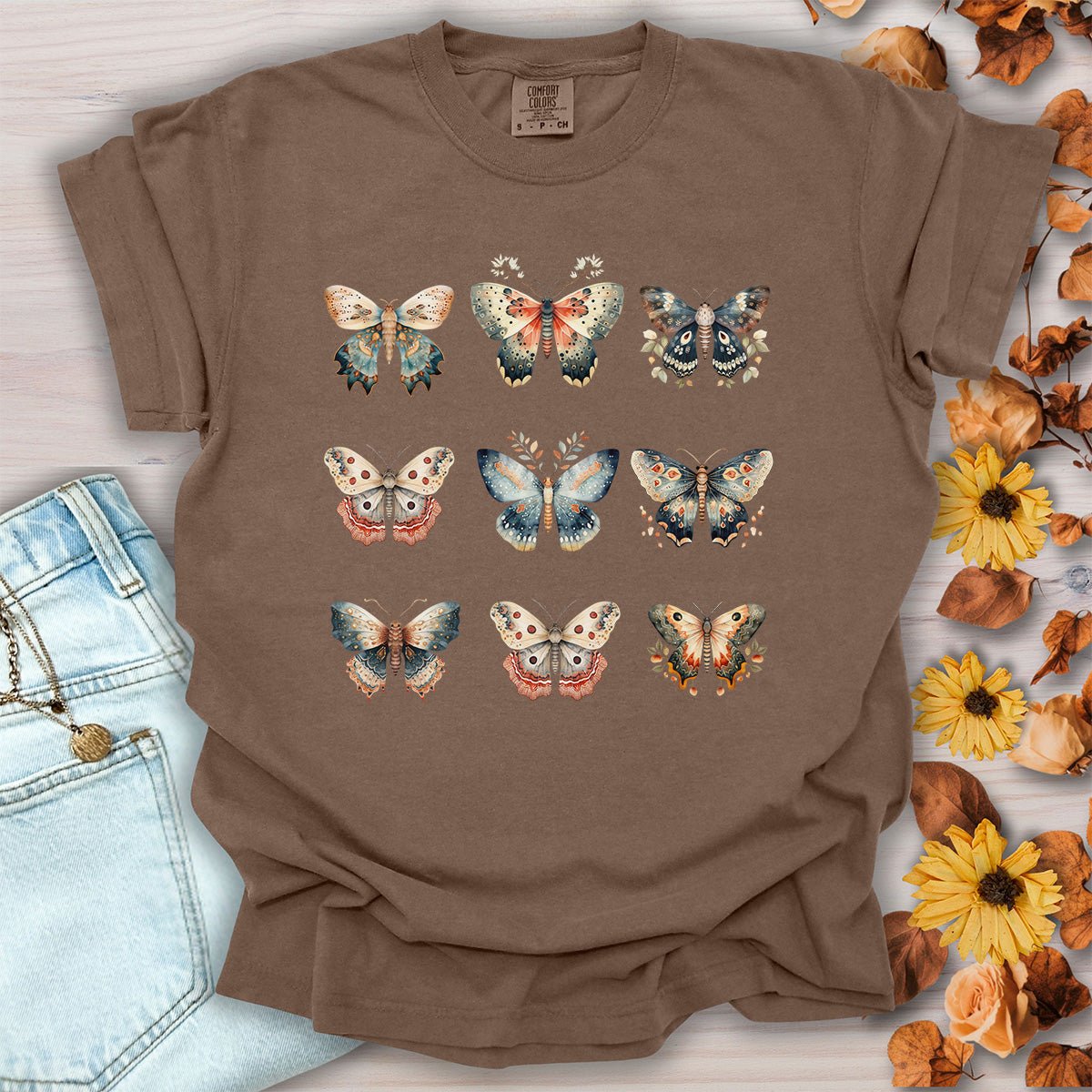 Espresso brown garment-dyed cotton t-shirt featuring a vintage watercolor grid of moths and butterflies, size small.