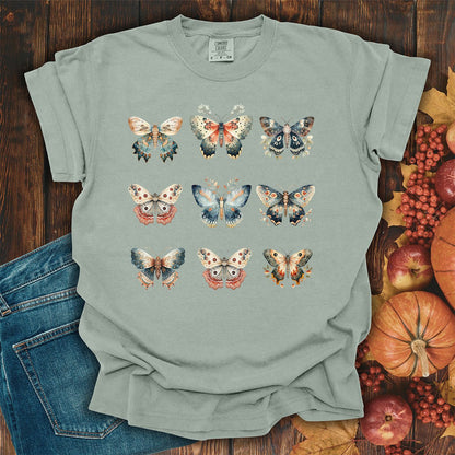 Bay-colored heavyweight cotton t-shirt featuring a grid of vintage watercolor moth and butterfly illustrations.