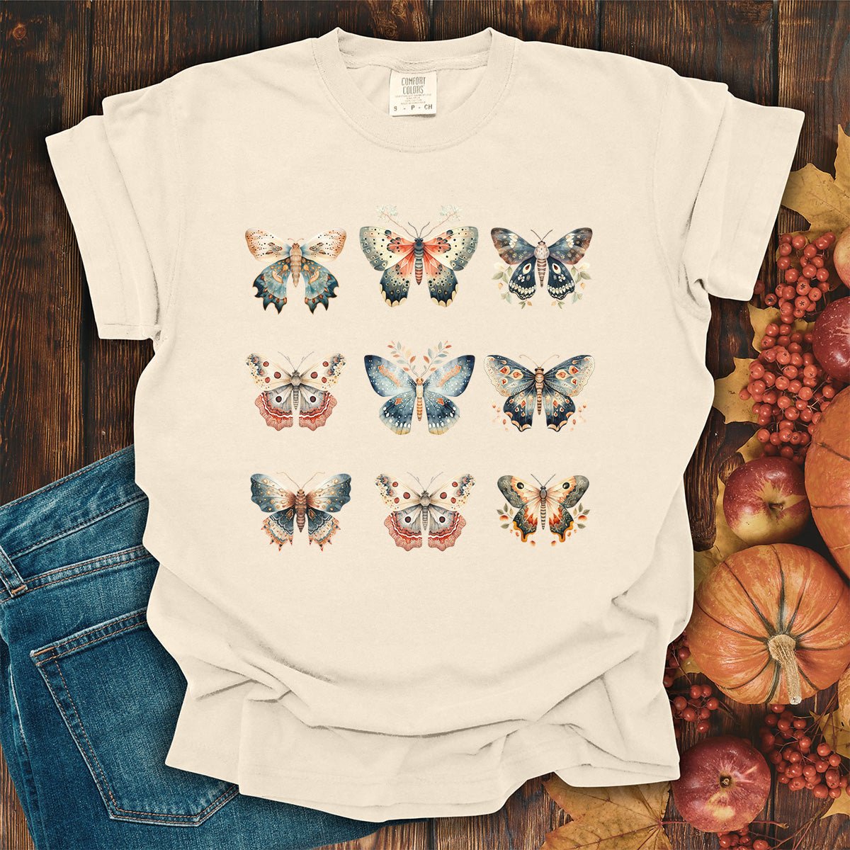 Ivory heavyweight cotton t-shirt featuring a vintage watercolor grid of moths and butterflies in a relaxed, garment-dyed fit.
