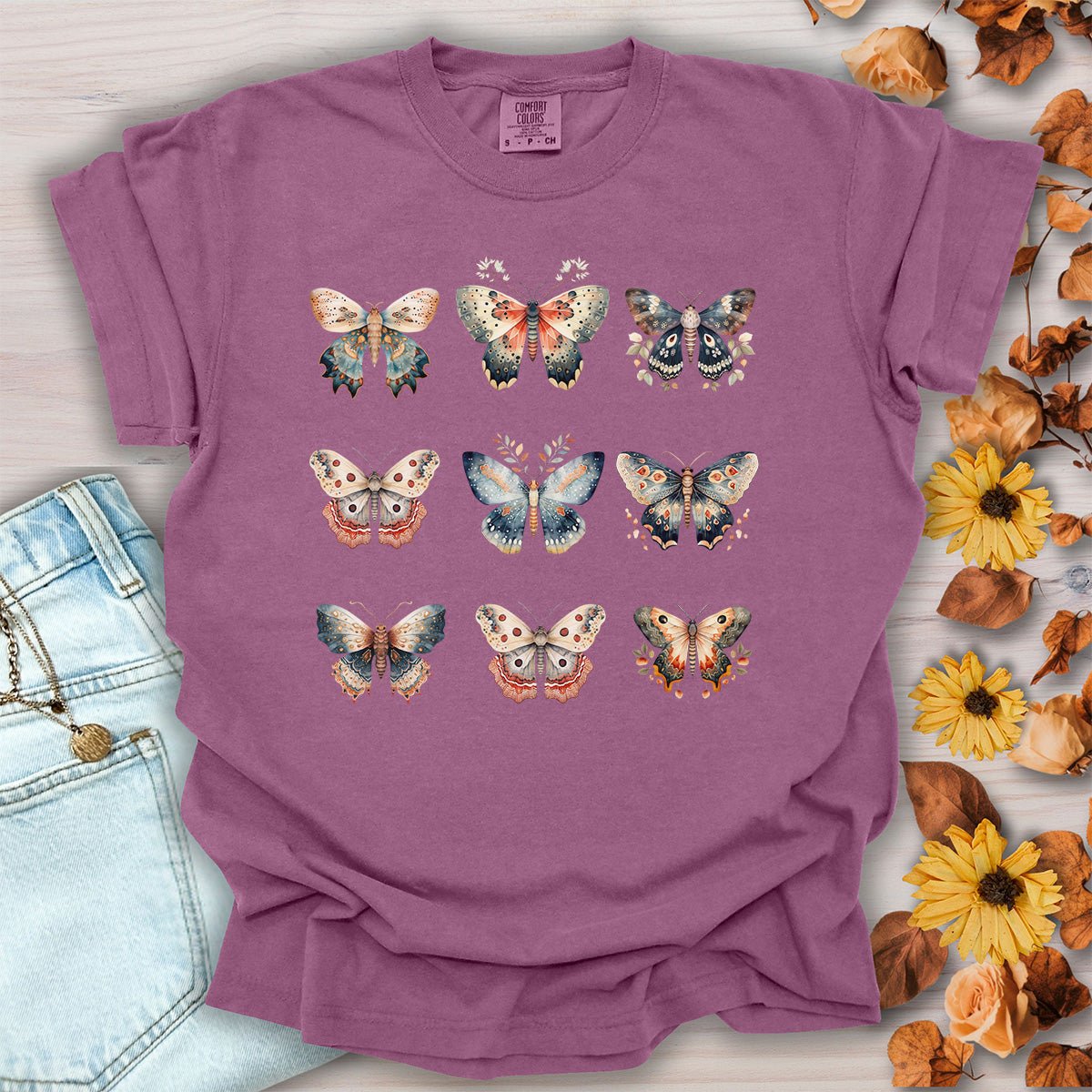 Berry-colored heavyweight cotton t-shirt featuring a vintage watercolor grid of moths and butterflies in a relaxed fit.