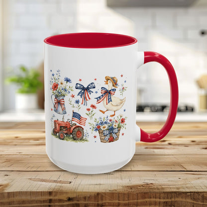 15oz white ceramic mug with red handle/interior, featuring a patriotic farmhouse goose, tractor, and floral design.