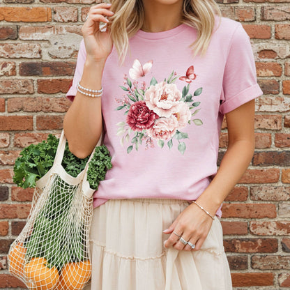 Woman in a pink vintage peony & butterfly bouquet t-shirt, holding a mesh bag of produce.