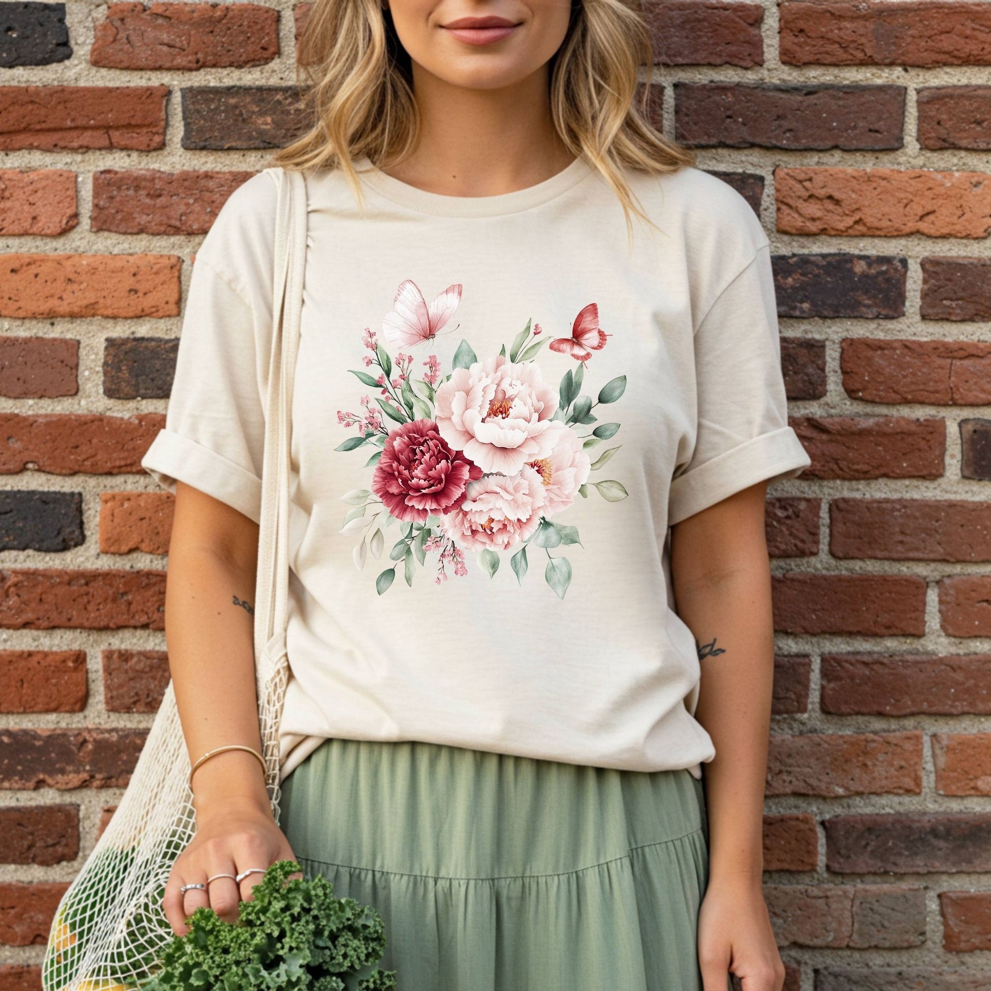 Woman in a relaxed-fit, garment-dyed beige t-shirt with a vintage peony and butterfly bouquet design.