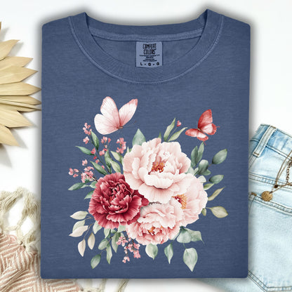 Denim blue garment-dyed cotton t-shirt with a watercolor peony and butterfly bouquet design.
