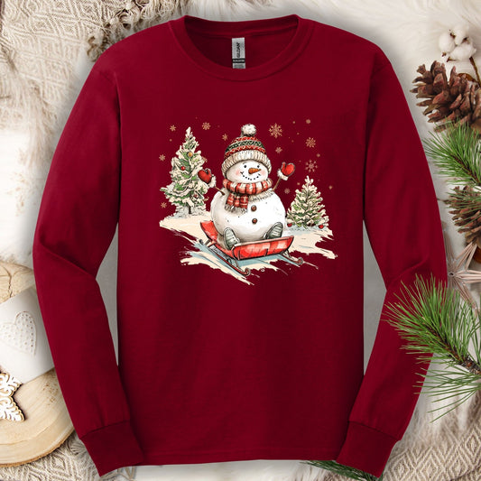Cardinal Red Gildan long sleeve tee with a vintage snowman sledding design.