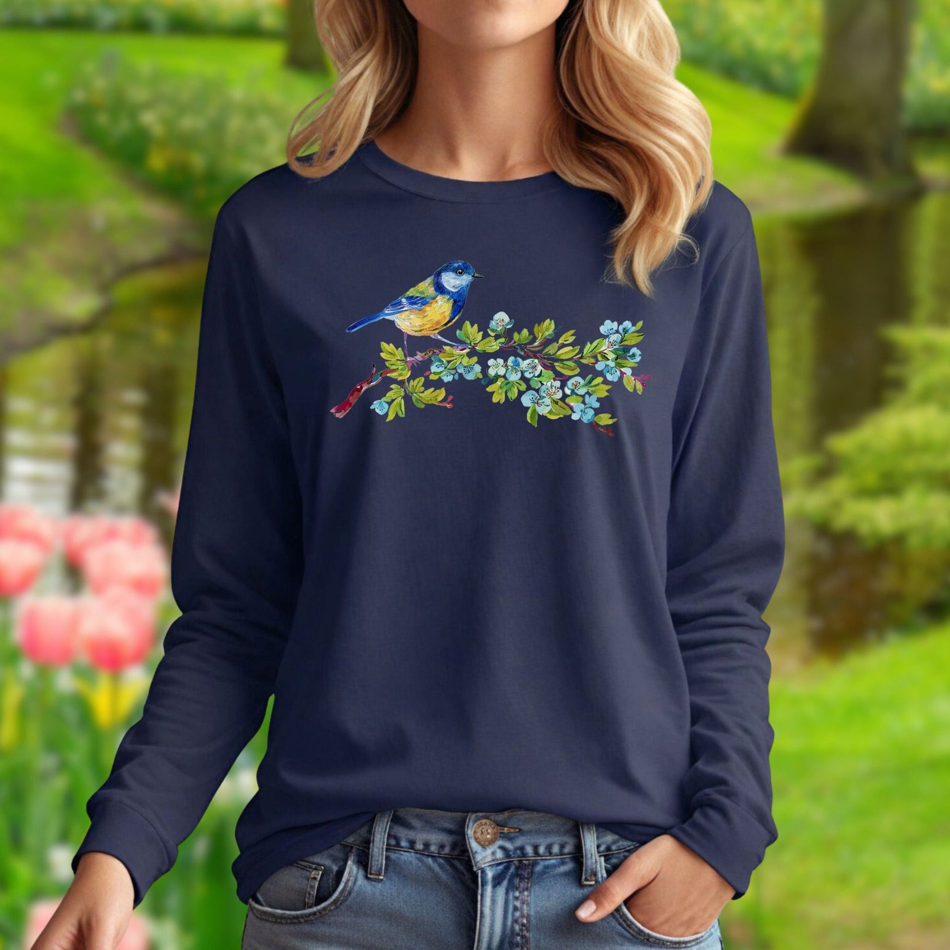 Navy long sleeve tee with a watercolor blue bird on a budding branch design across the chest.